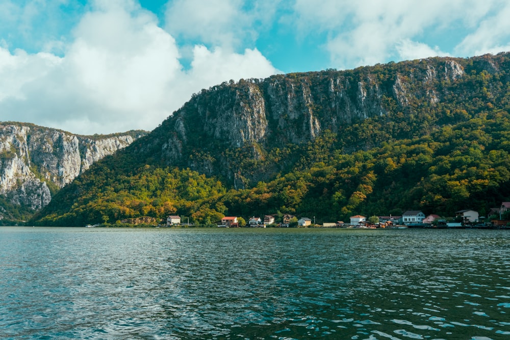 body of water near mountain during daytime