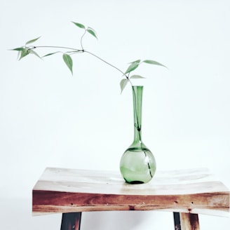 green glass vase on brown wooden table