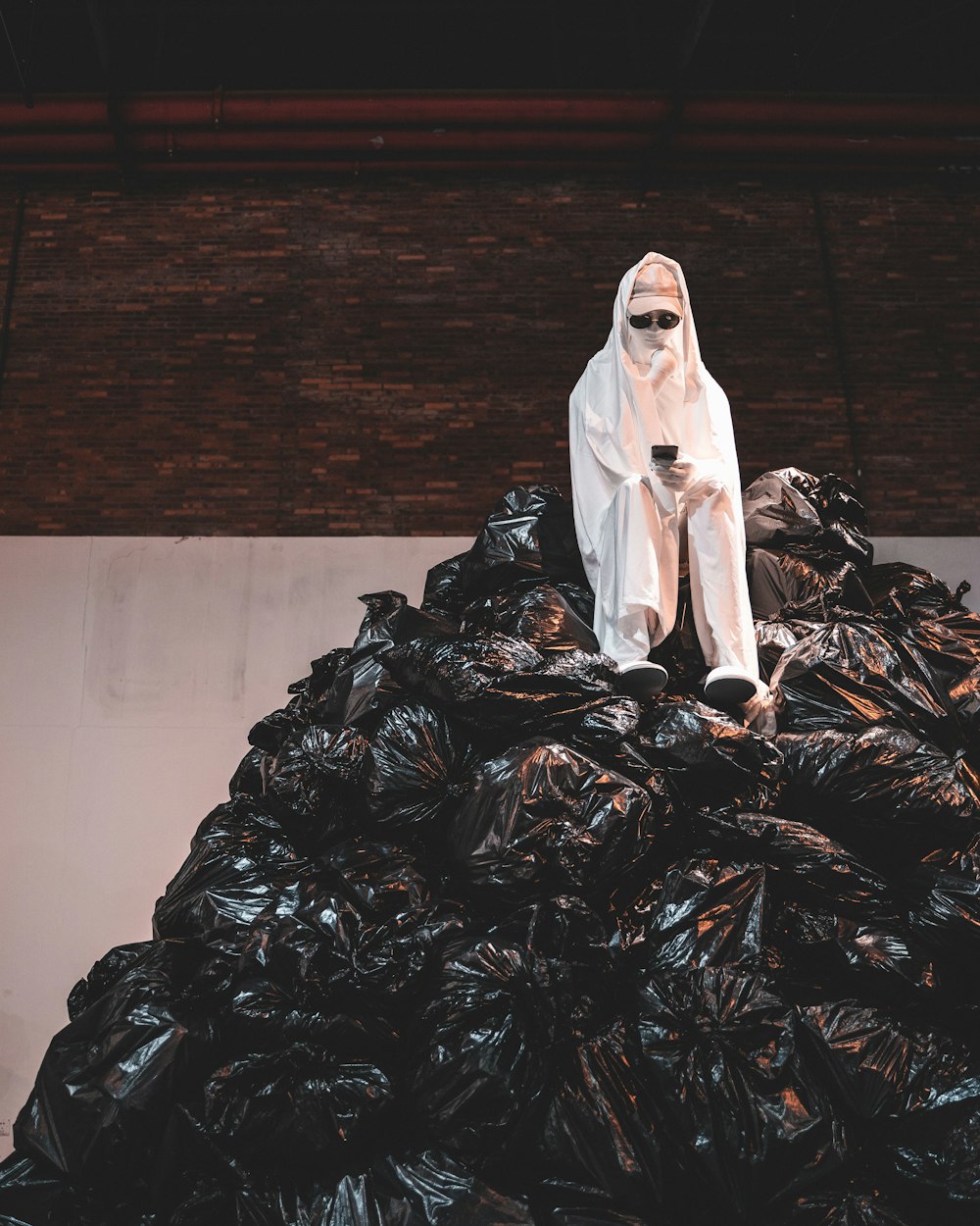 woman in white dress sitting on black plastic bag