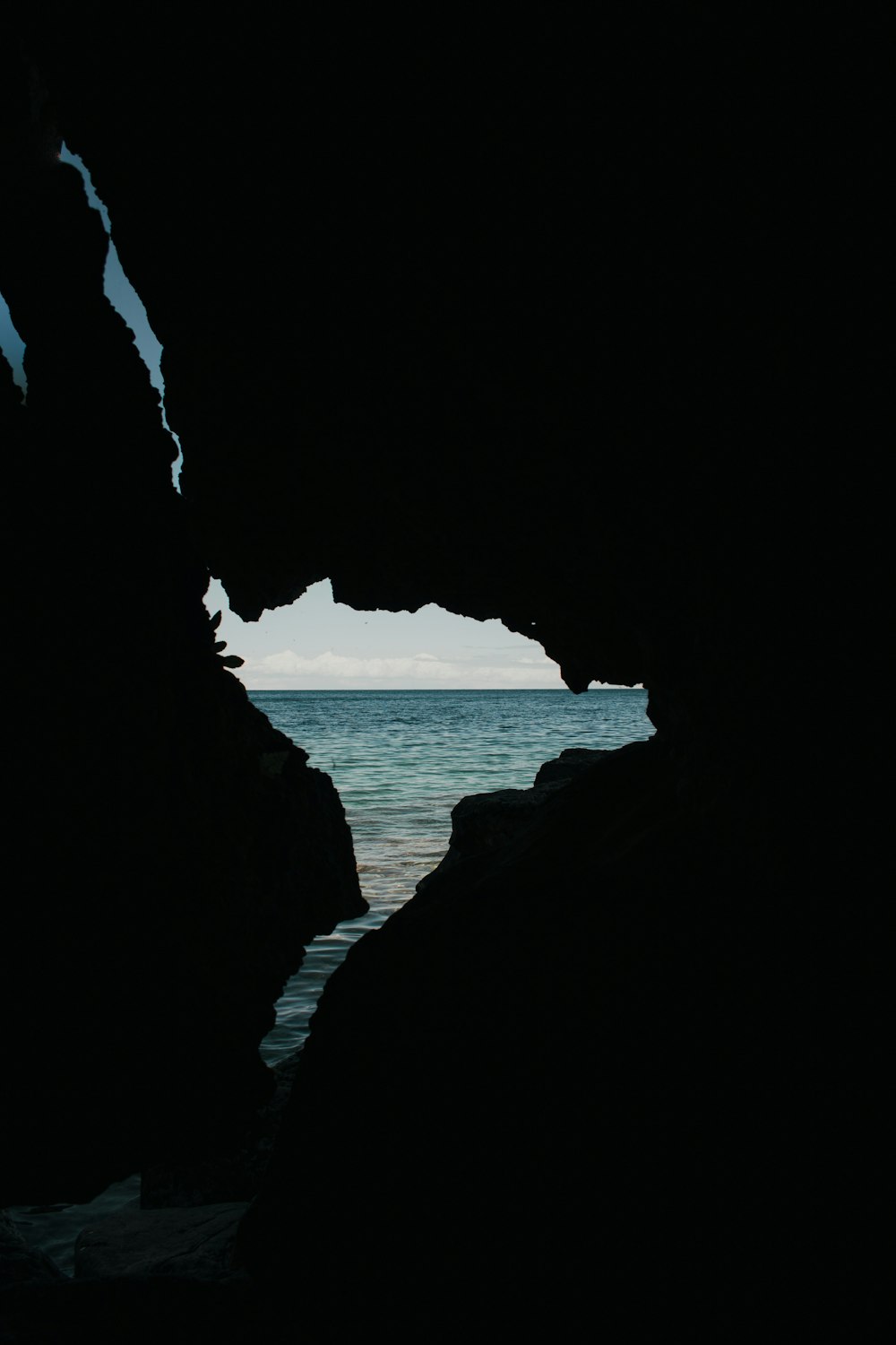 cave near body of water during daytime