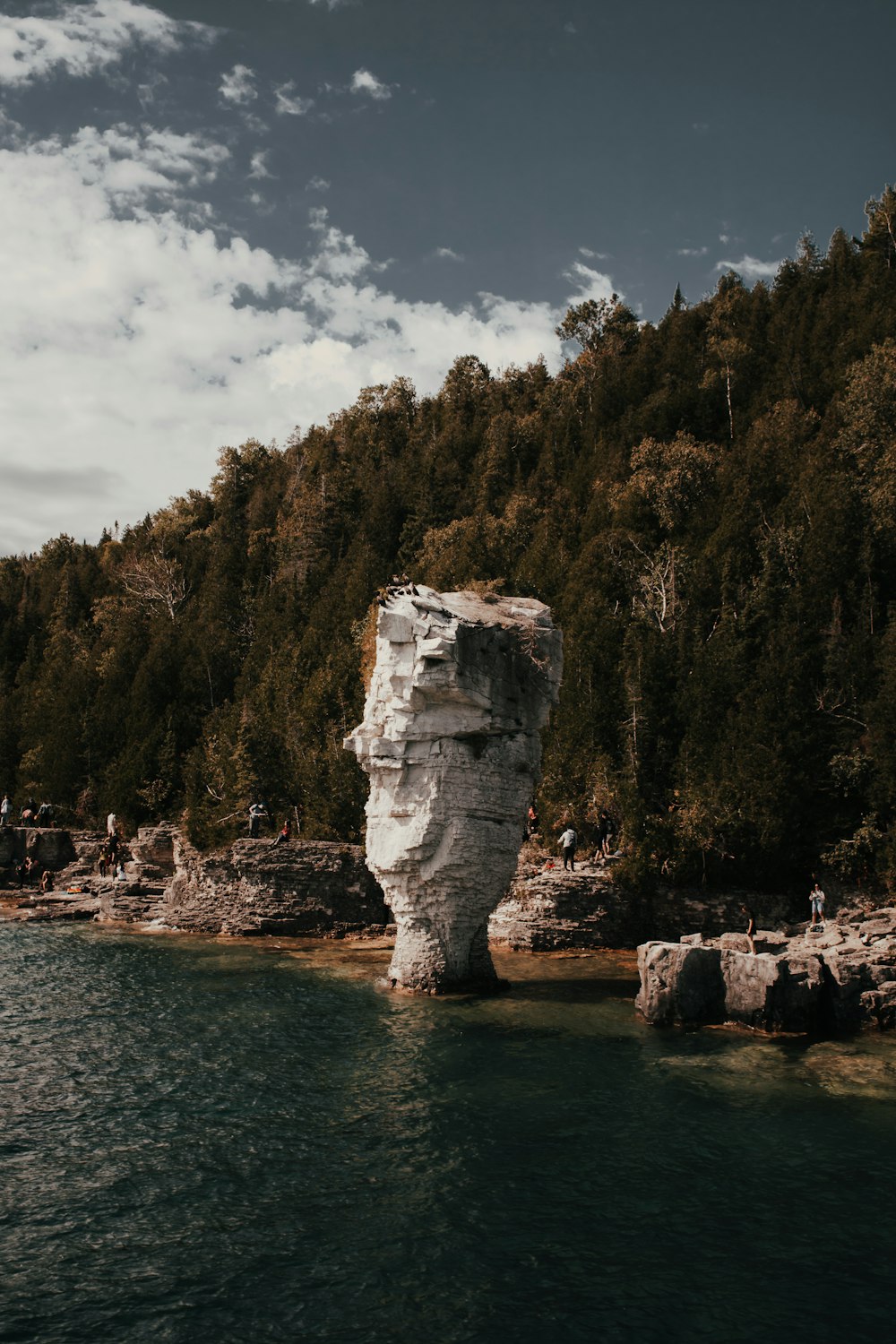 gray rock formation on body of water during daytime