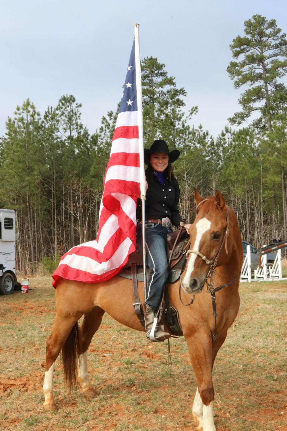 man in blue white and red striped polo shirt riding brown horse during daytime