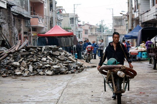 people riding on brown wooden cart during daytime in Guizhou China