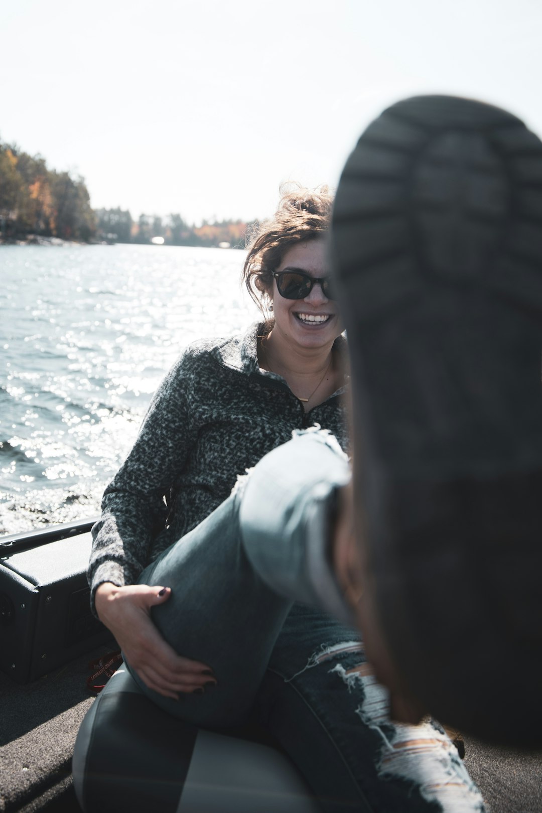 woman in blue denim jacket and black sunglasses sitting on boat during daytime