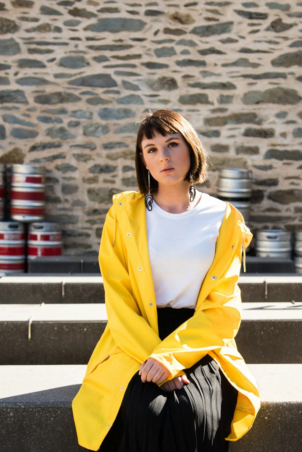 woman in yellow blazer sitting on gray concrete bench