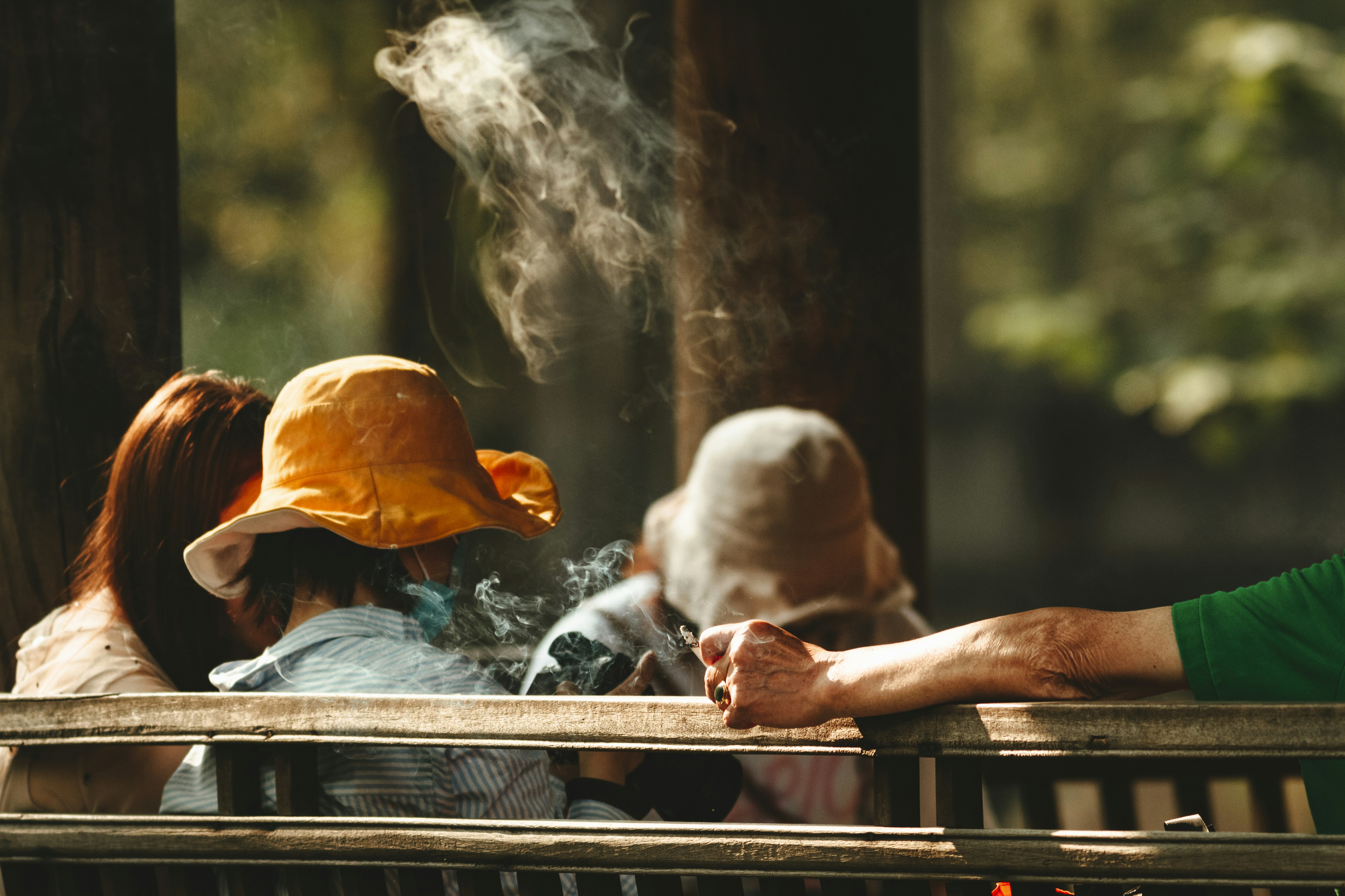 Person im weißen Hemd sitzt auf brauner Holzbank