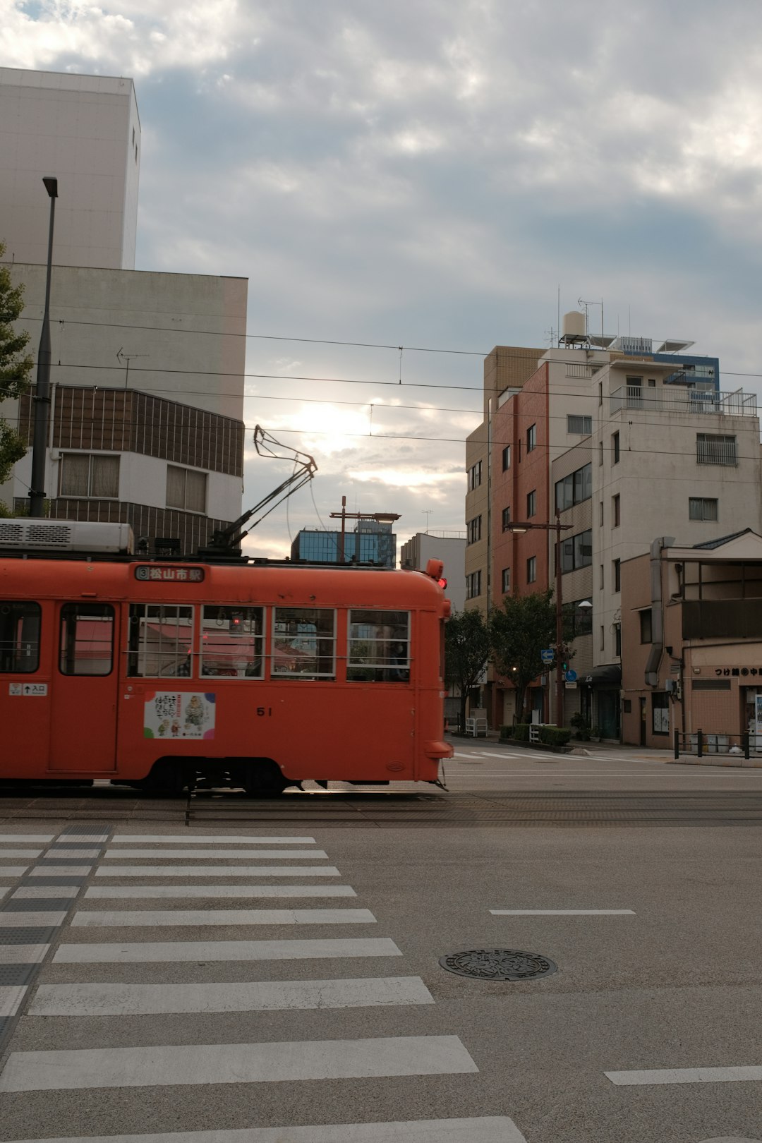 red tram on road near building during daytime