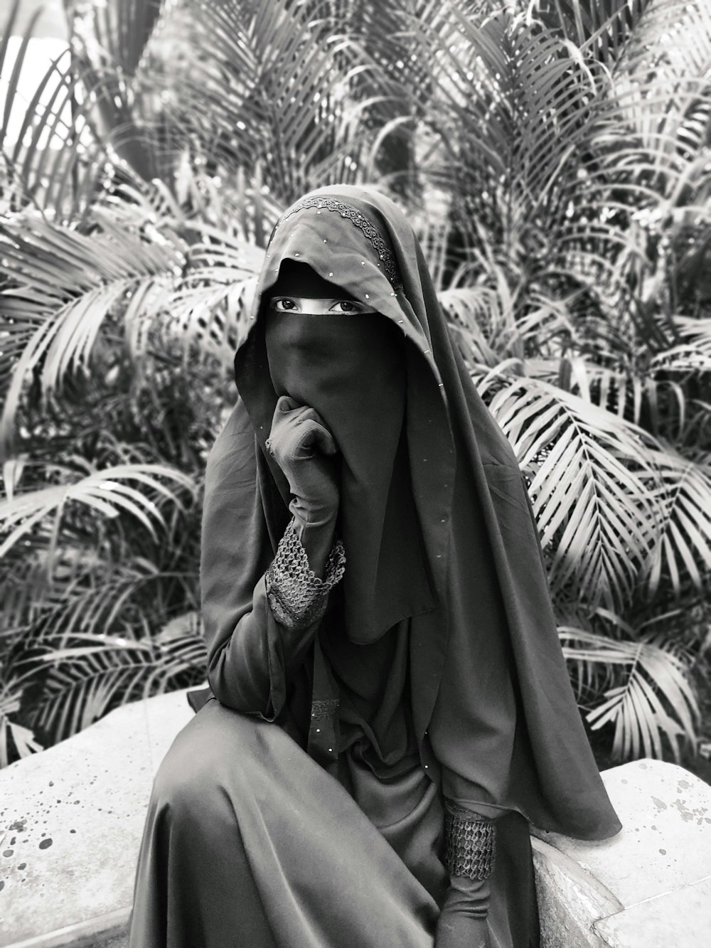 woman in brown hijab sitting on white textile