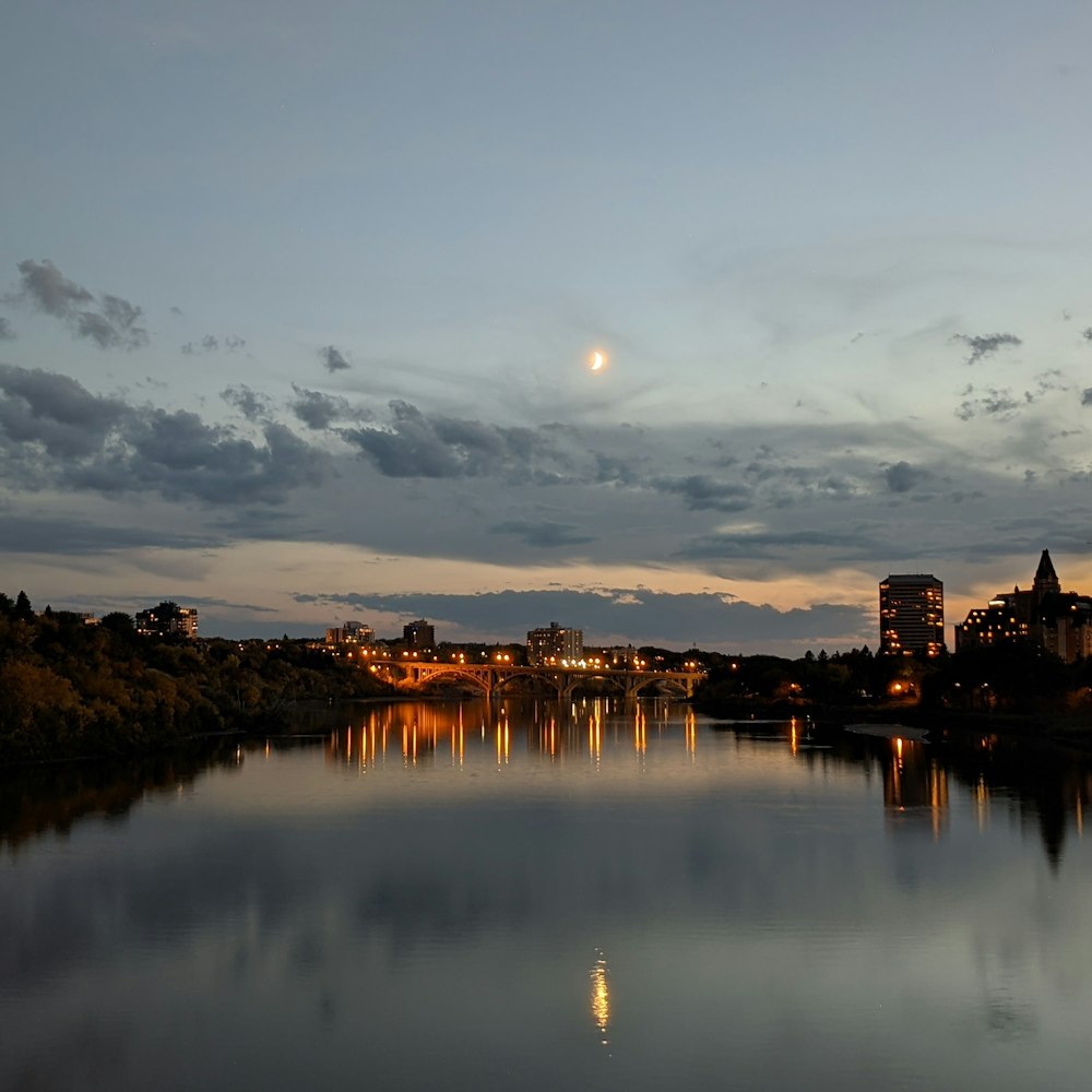 Plan d’eau près des bâtiments de la ville au coucher du soleil