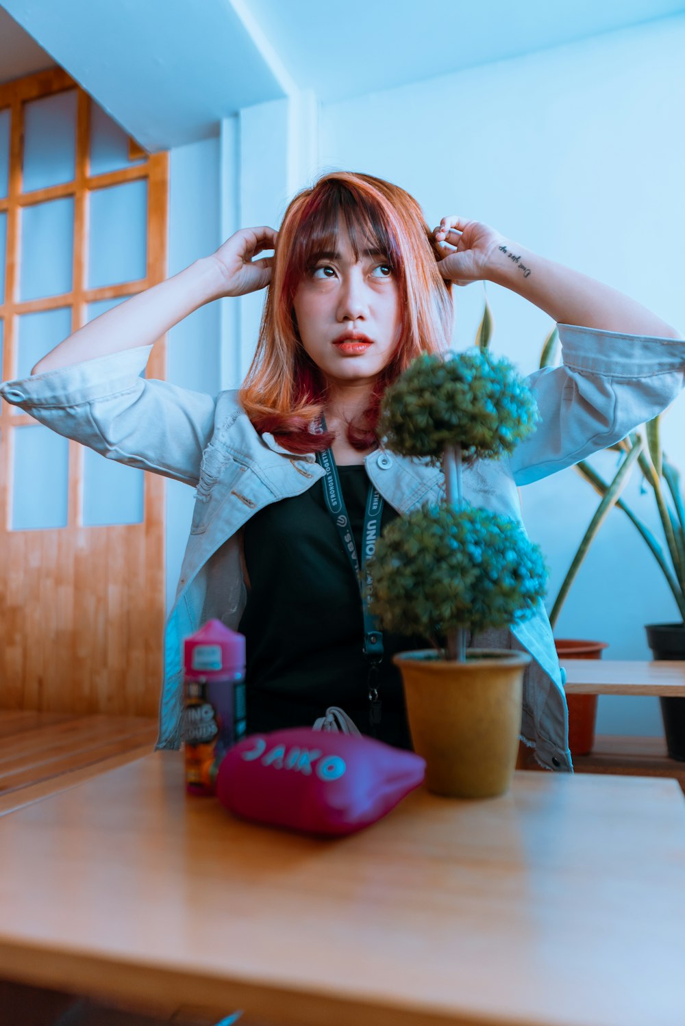 woman in black jacket holding green cactus plant