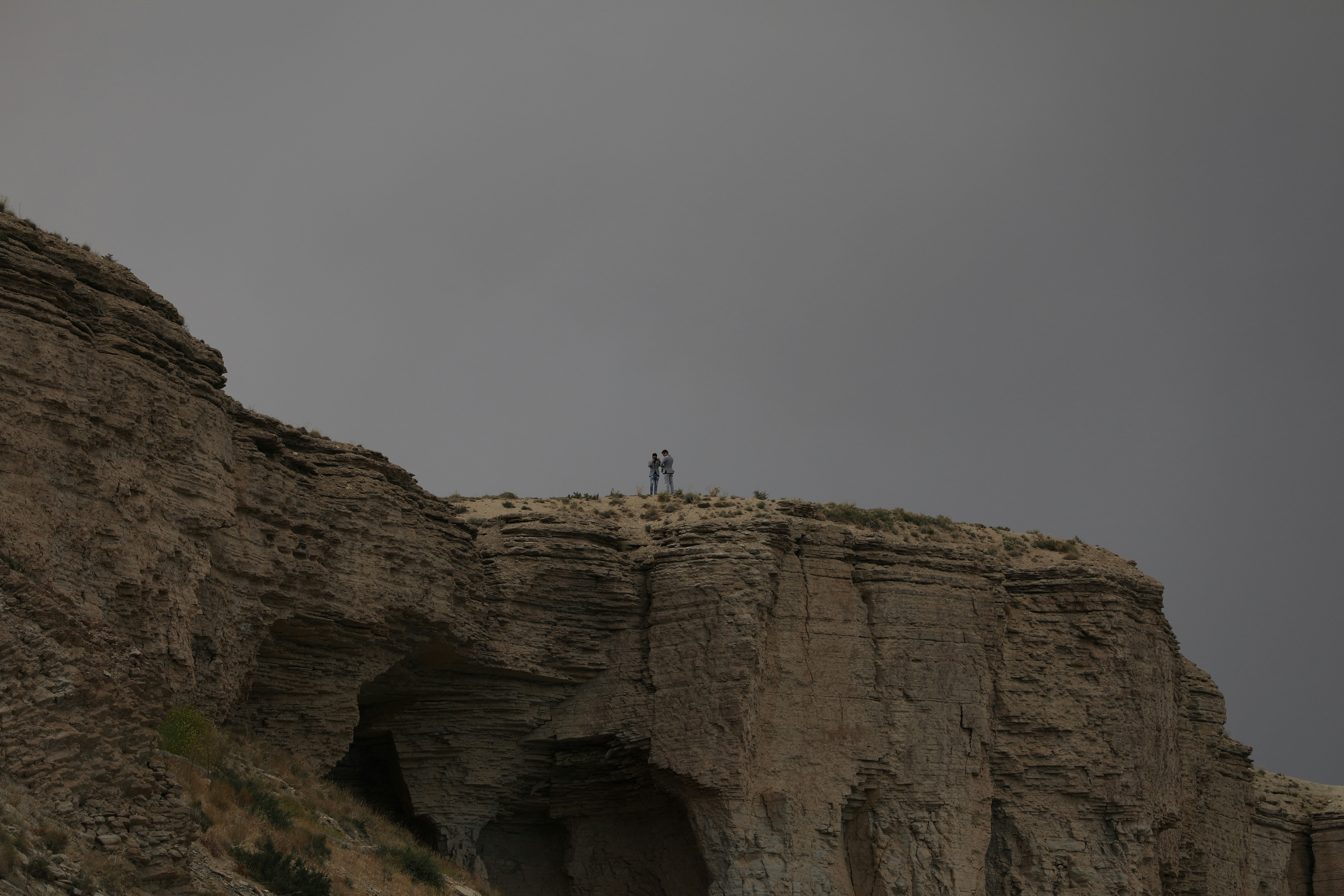 person standing on brown rock formation during daytime afghanistan teams background