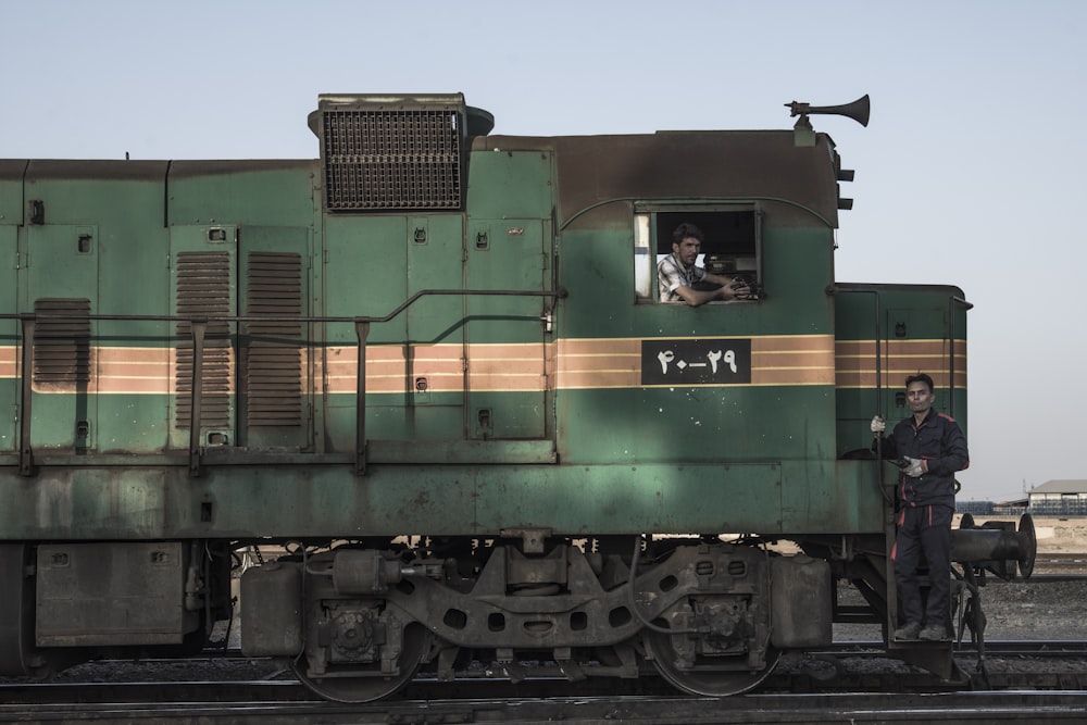 trem verde e marrom nos trilhos ferroviários durante o dia