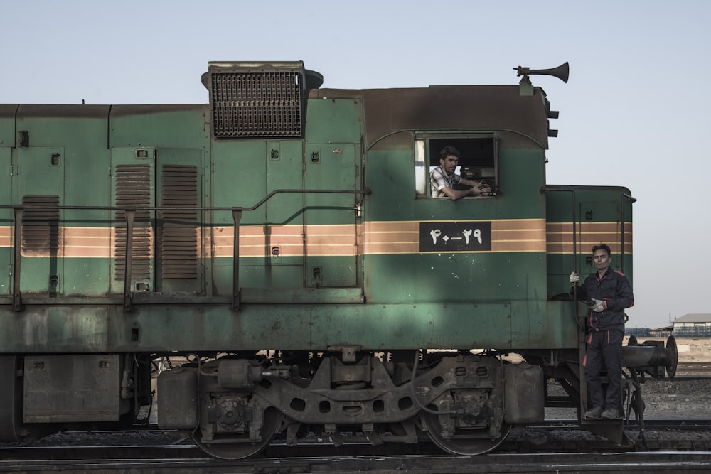 green and brown train on rail tracks during daytime