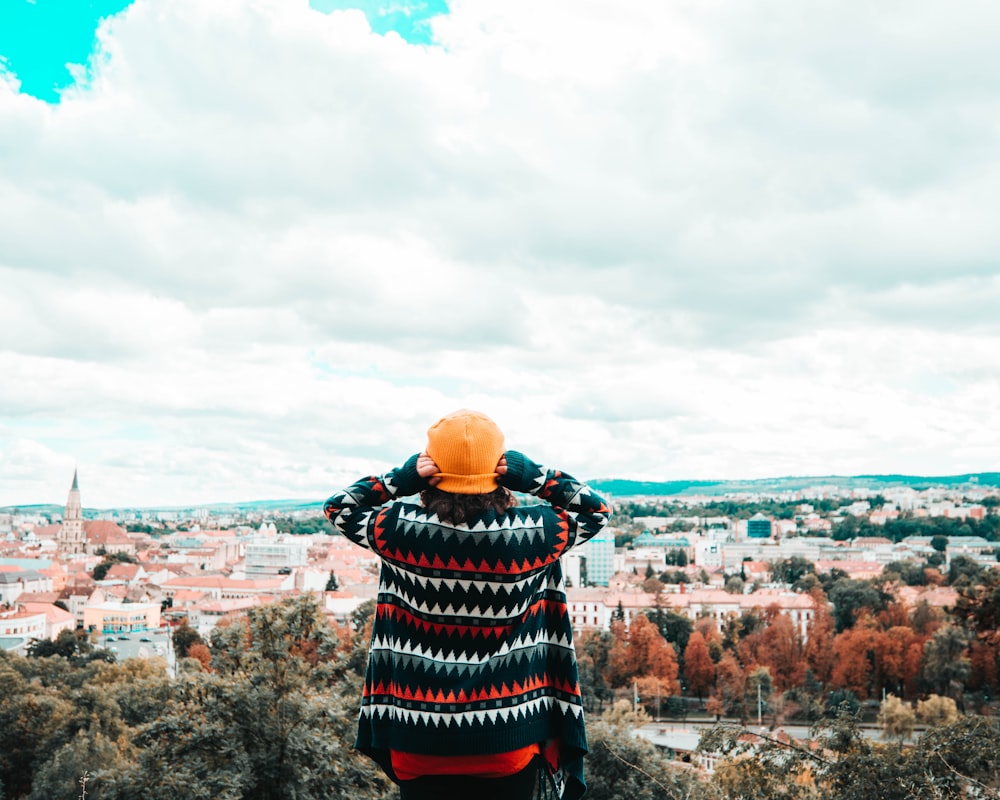 person in black and red plaid dress shirt standing on rock formation during daytime