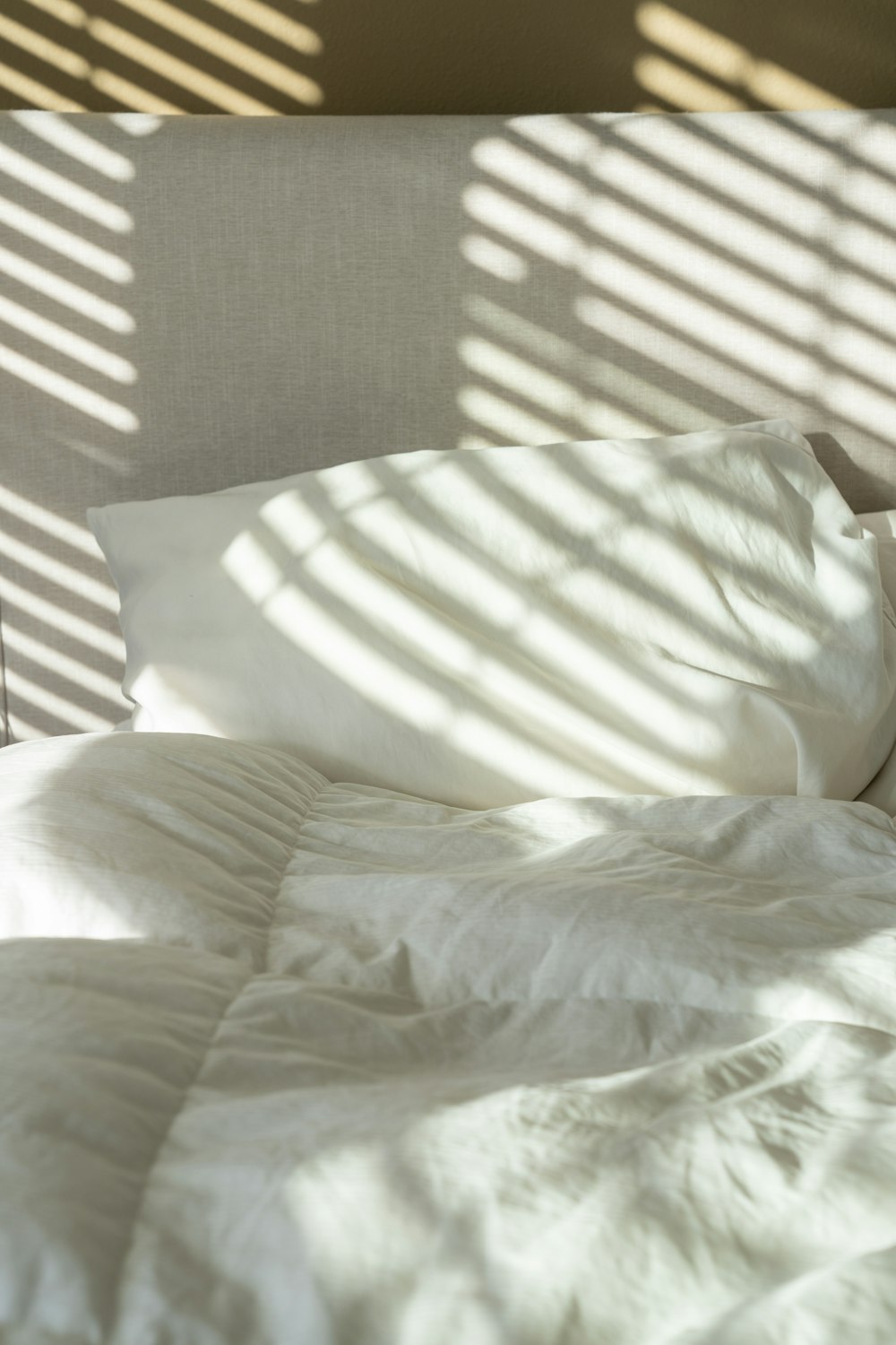 a bed with white sheets and white pillows