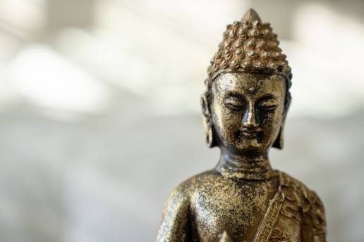 gold buddha statue in close up photography