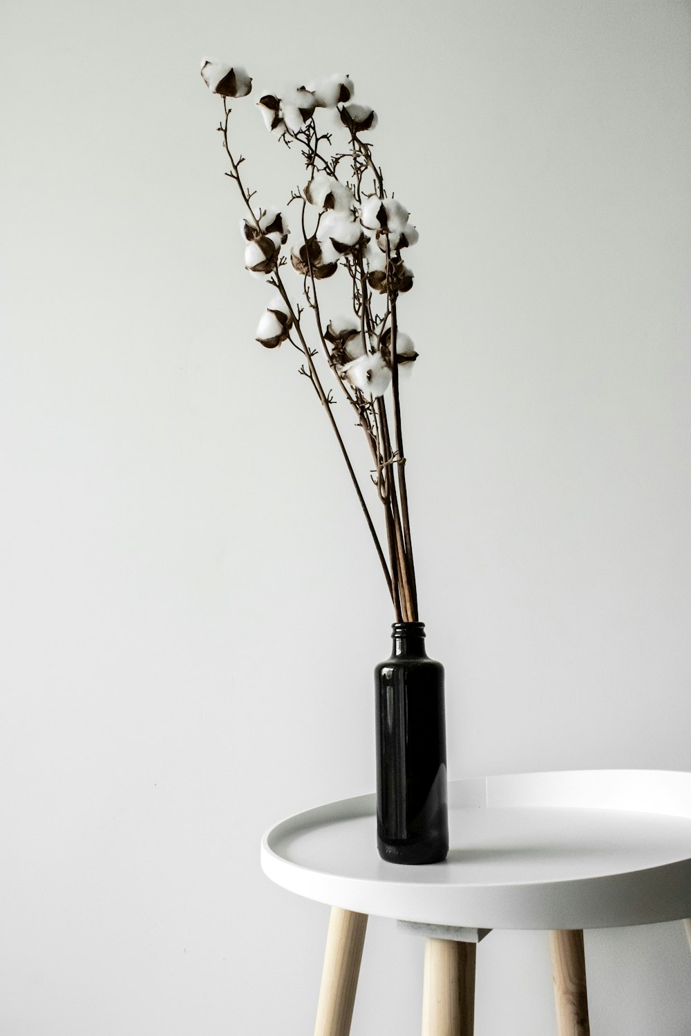 white flowers in black glass vase