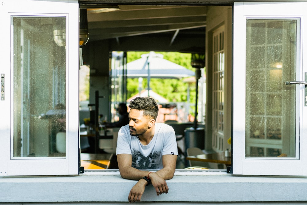 man in gray crew neck t-shirt sitting on white table