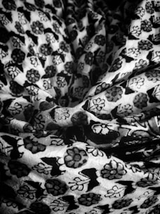 Close-up of patterned linen fabric with intricate floral designs spread out on a table.