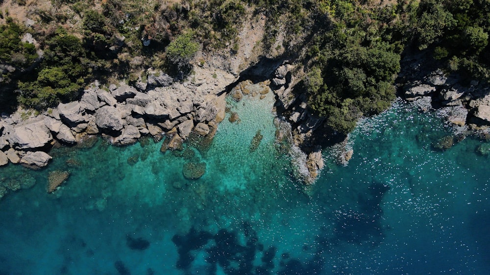 aerial view of green and brown rocky mountain beside body of water during daytime