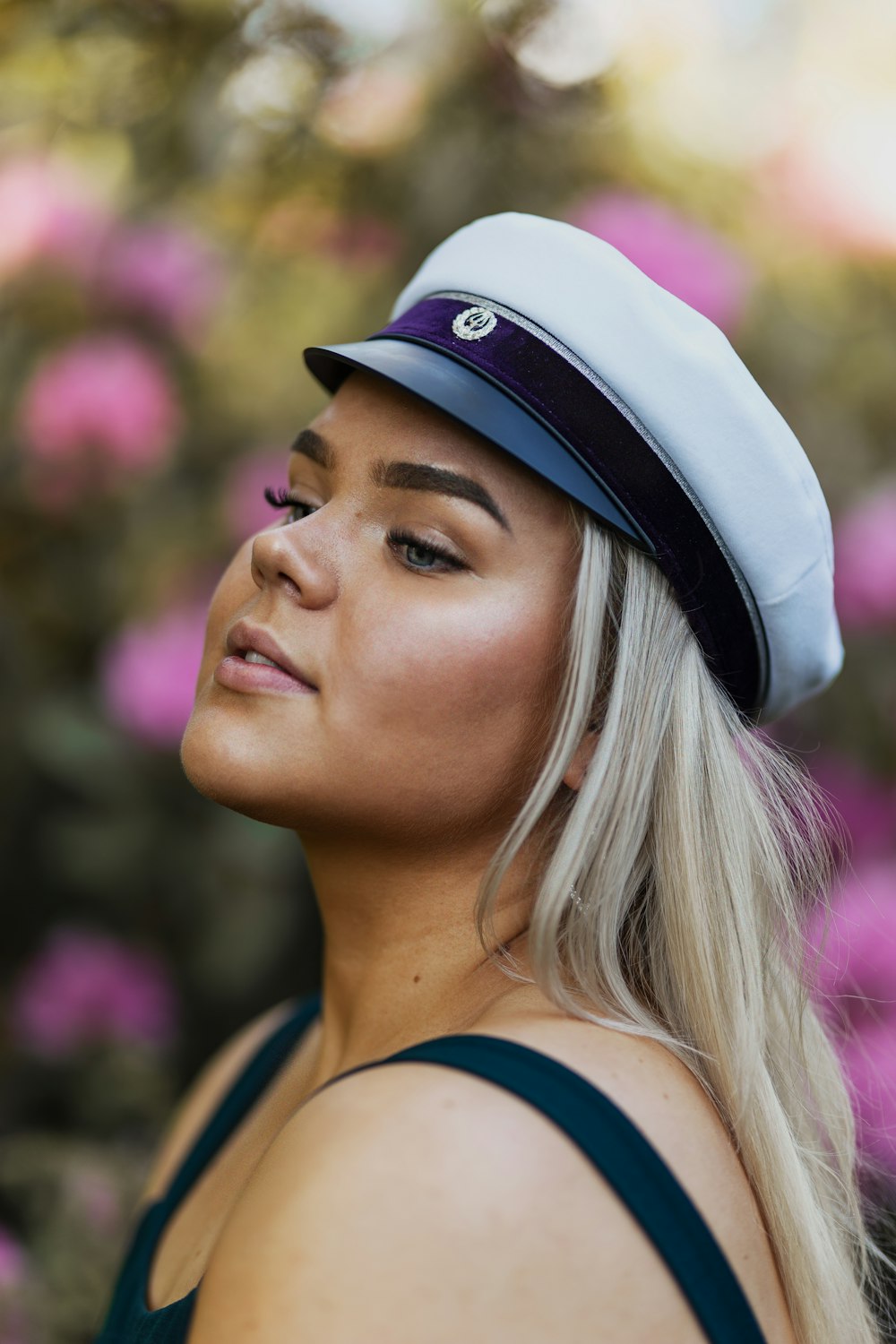 woman in black tank top wearing white and black cap