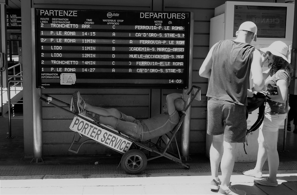 man in white t-shirt and gray shorts lying on folding chair