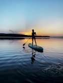 man in black shirt riding on green kayak on body of water during daytime