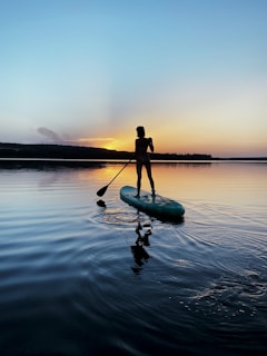 man in black shirt riding on green kayak on body of water during daytime