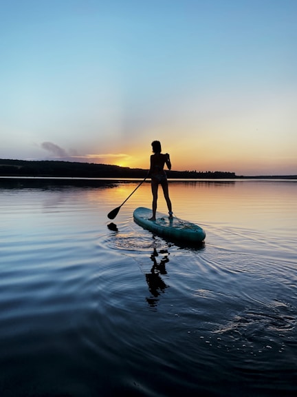 man in black shirt riding on green kayak on body of water during daytime