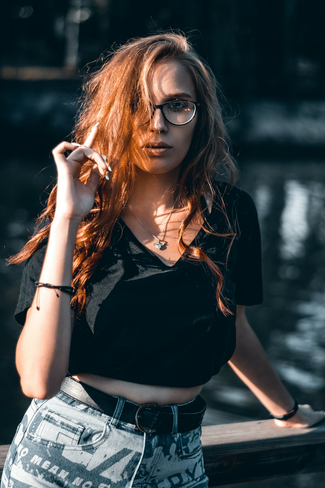 woman in black sleeveless shirt and gray pants wearing black framed sunglasses