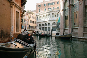 A serene canal in Venice with gondolas gently floating under ancient bridges.
