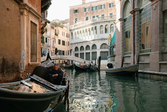 A serene canal in Venice with gondolas gently floating under ancient bridges.