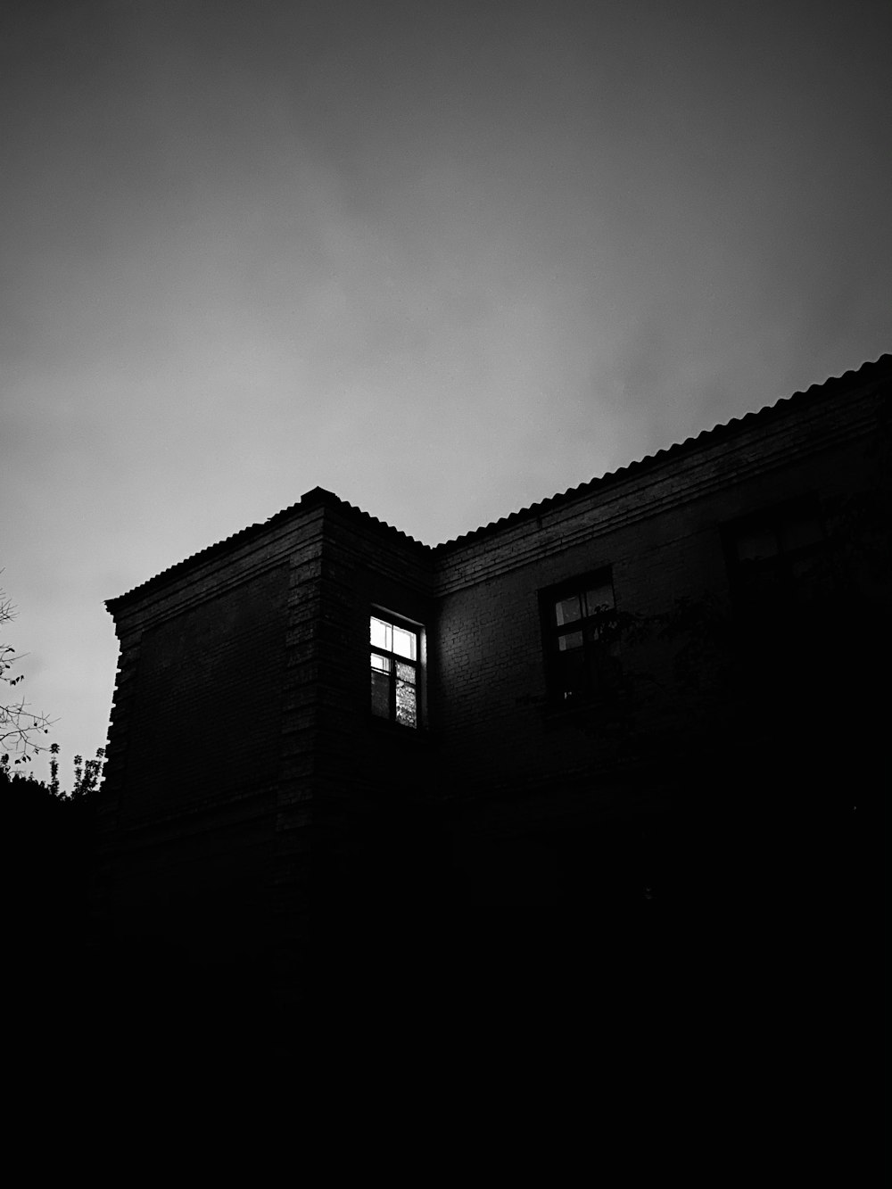 grayscale photo of building under cloudy sky