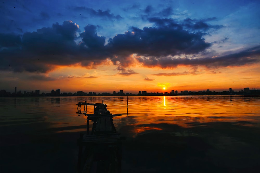 silhouette of people on dock during sunset