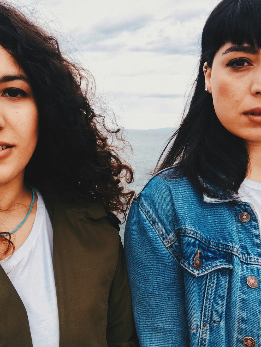 woman in blue denim button up jacket beside woman in white shirt