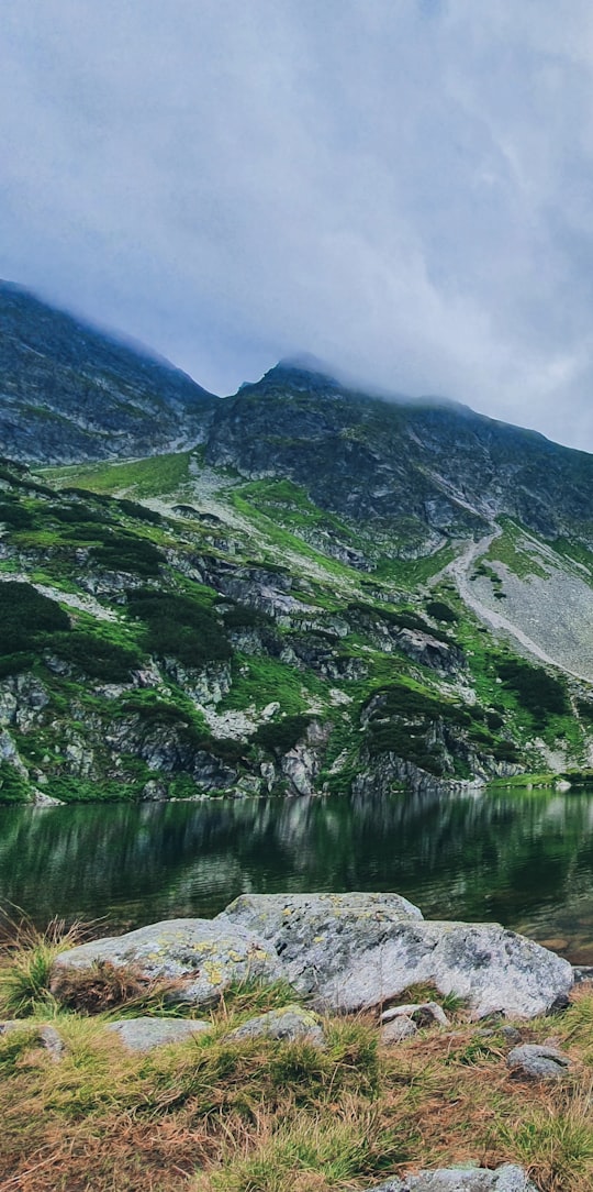 green and gray mountain beside lake during daytime in Tatry Poland