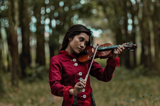 woman in red jacket playing violin in Pekanbaru Kota Indonesia