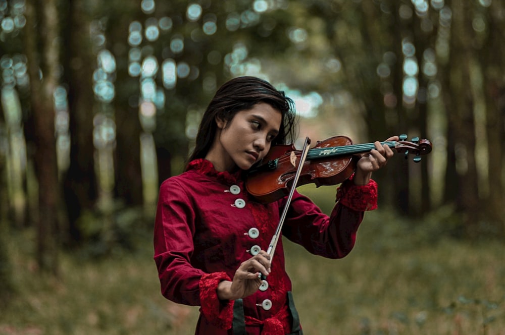 woman in red jacket playing violin