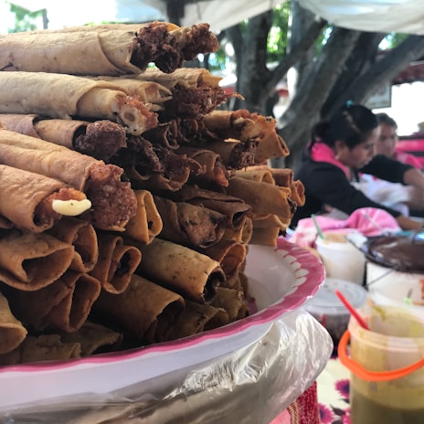 Taquito celebrating victory with a pile of tacos under a bright, colorful sky.