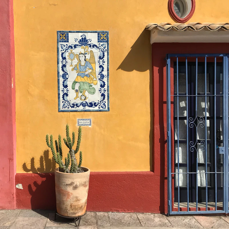 Ventana de herrería sobre muro pintado de naranja