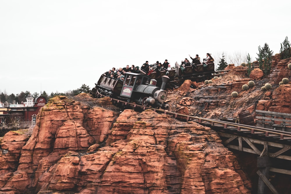 people riding on white suv on brown rocky mountain during daytime