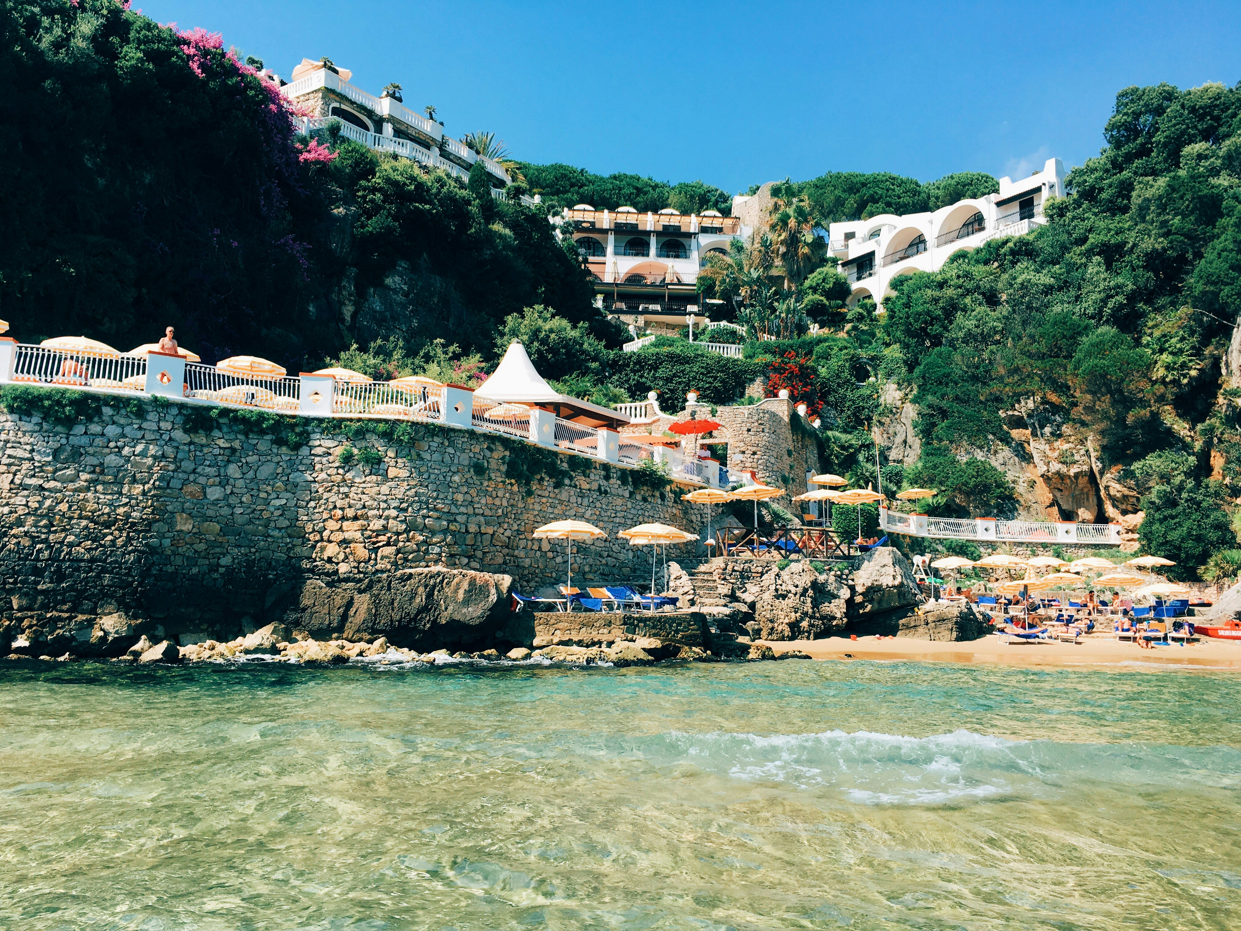 white and brown concrete building near body of water during daytime, 