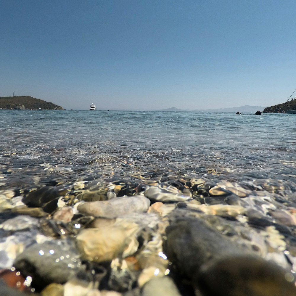 person in black shirt standing on rocky shore during daytime