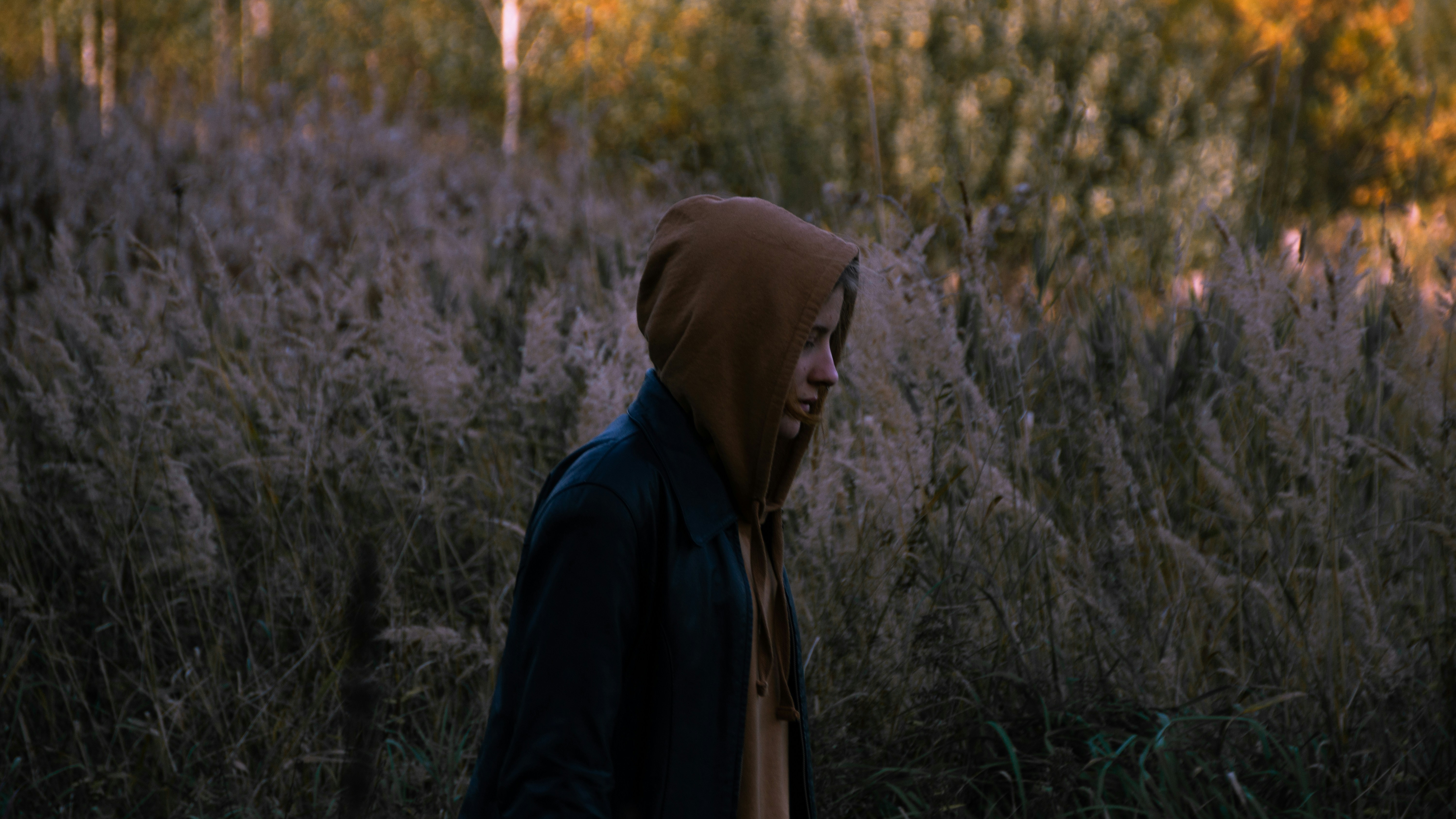 person in black hoodie standing on green grass field during daytime