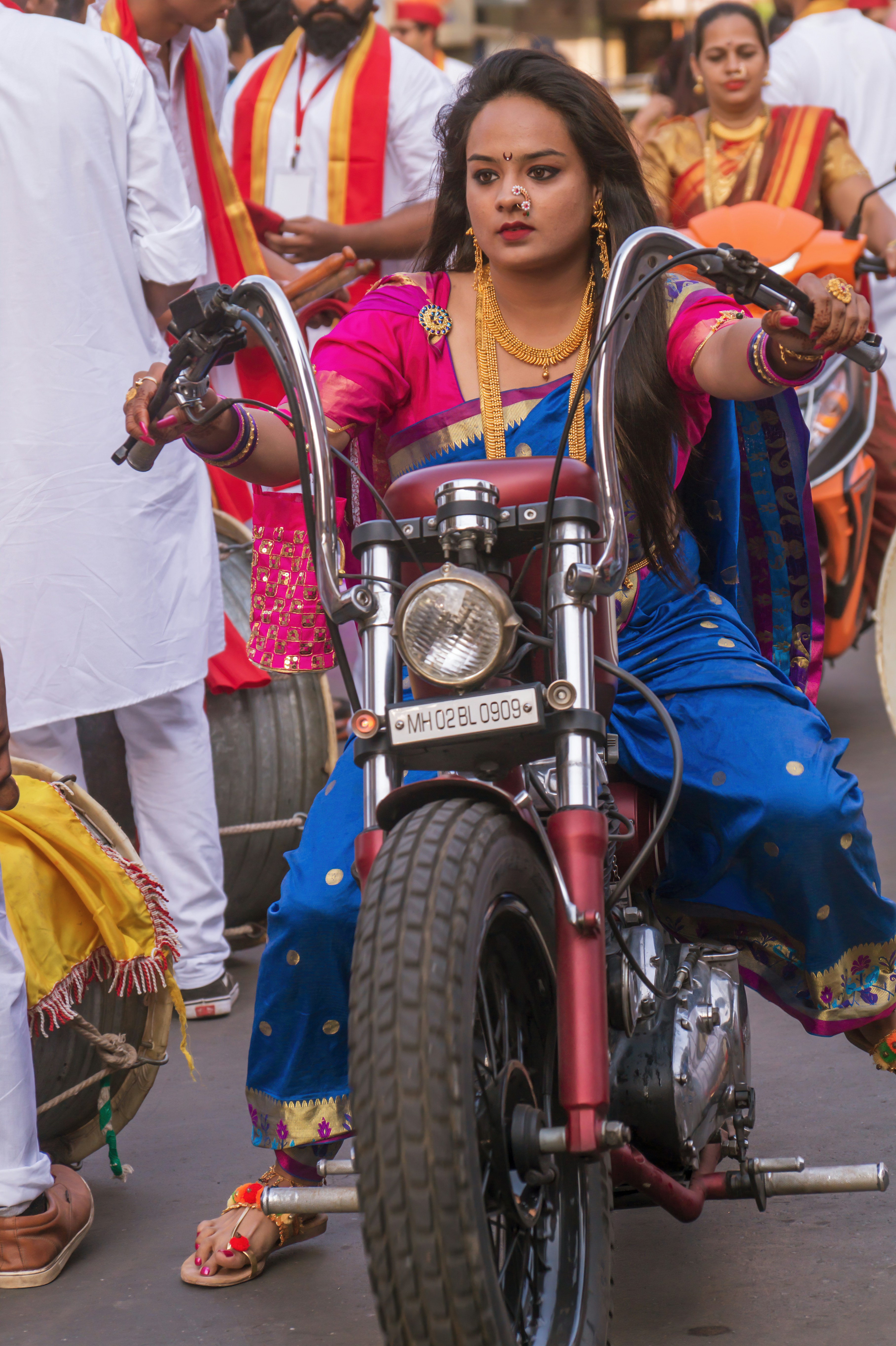 girl in blue and white dress riding on red motorcycle