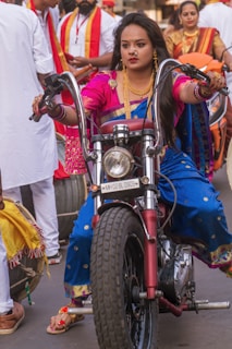 girl in blue and white dress riding on red motorcycle