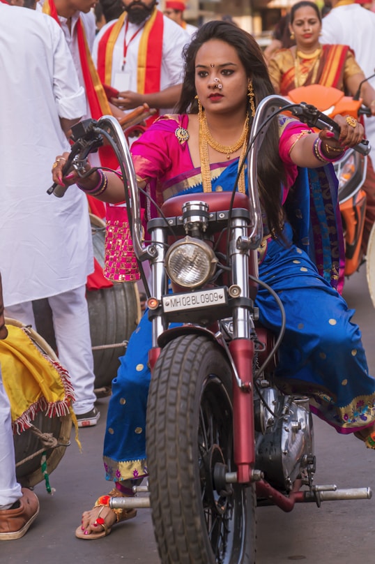 girl in blue and white dress riding on red motorcycle