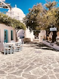 white plastic chairs and tables outside blue concrete building
