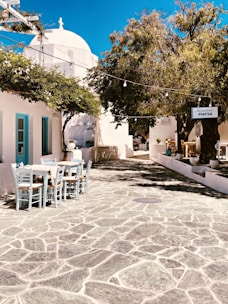 white plastic chairs and tables outside blue concrete building