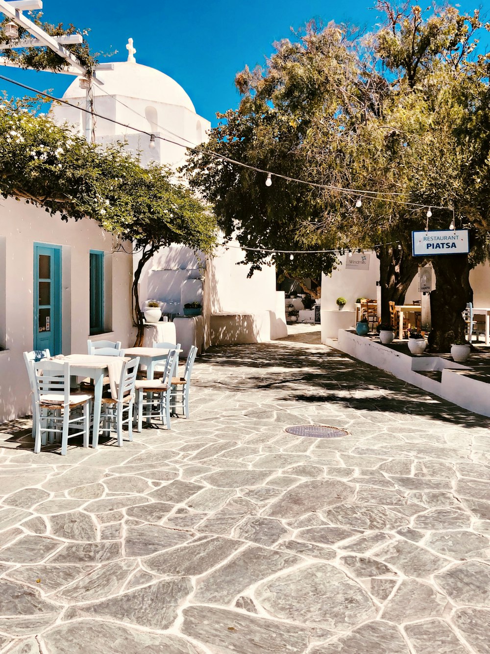 white plastic chairs and tables outside blue concrete building